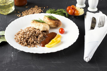 Chicken cutlets with buckwheat, herbs, ketchup and tomatoes