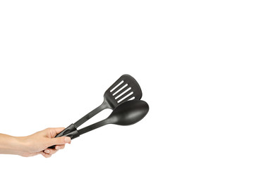 Hand with Black plastic kitchen spoon and spatula, kitchenware for cooking
