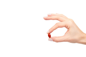 red vitamin capsule in blister with hand, medicine supplement