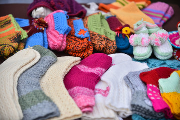 A row of multicolored hand-knitted baby socks