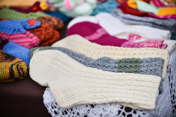 A row of multicolored hand-knitted baby socks