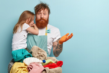 Busy overloaded father looks after little daughter and does household chores, has puzzled fatigue...