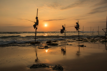 silhouette of fishermen in stick when sunset on the sea at Koggala Sri Lanka