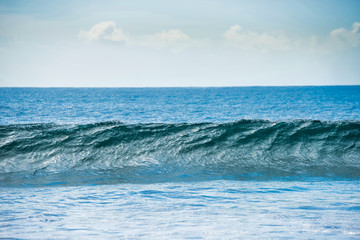 Naklejka na ściany i meble Calm blue seascape with white surf wave on foreground