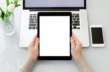 Female hands holding tablet with isolated screen laptop and phone