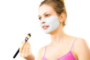 Girl apply green mud mask to face
