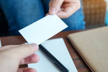 Obraz premium A woman holding and giving empty business card to someone