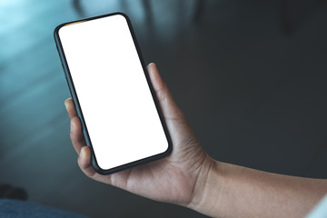Mockup image of a woman's hand holding black mobile phone with blank desktop screen