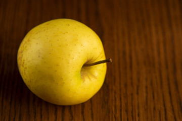 Yellow apple on the wooden vintage background