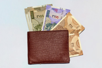 Close up shot of wallet with brand new Indian 10, 100,and 500 rupees banknotes on white isolated background and copy space.