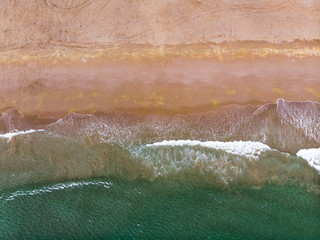 Fototapeta premium Waves splashing the sea shore aerial view