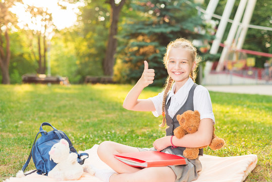 happy girl student smiling. schoolgirl in uniform happily shows gesture everything is fine thumbs up. tutorial.