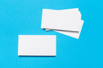 Blank white business cards on blue background. Mockup for branding identity.