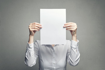 anonymous woman covering face with  paper sheet