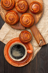 Breakfast with coffee and buns on wooden surface .  Top view