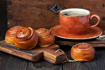 Breakfast with coffee and buns on wooden surface