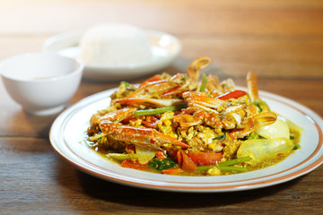 Top  view of Fried crab with curry powder, popular seafood menu in asia. Fried crab with curry powder, onion and egg on wooden background. Selective focus, shoot in studio. Clean food concept.