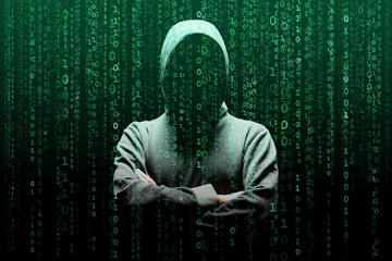 Computer hacker in mask and hoodie over abstract binary background. Obscured dark face. Data thief, internet fraud, darknet and cyber security.