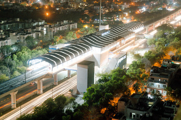 aerial shot of Delhi metro inaugration decoration at night with light trails