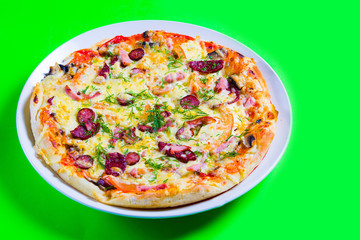 hot tasty fresh pizza on a plate close-up. green background