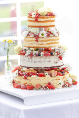 bunte Hochzeits -Torte mit Blumen und Beeren
