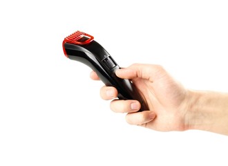 Hand holding black beard hair trimmer. Close up. Isolated on white background