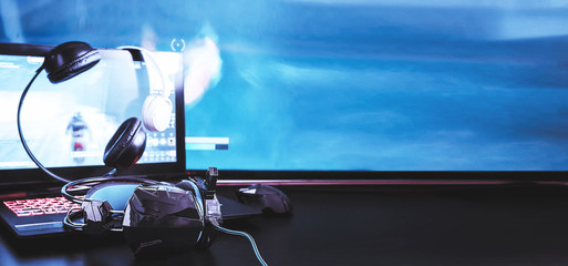 gamer workspace concept, game mechanism, mouse, keyboard headset, webcam, VR headset. Devices for cyber sport, e-sport on a black background table with digital symbols and text game. © shintartanya