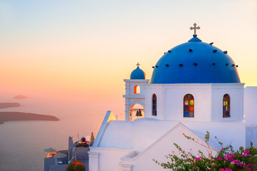 Church with blue dome at sunset on Santorini island, Greece.