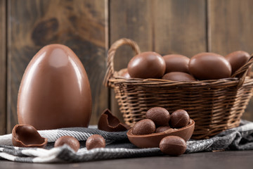 Chocolate Easter bunny, eggs and sweets on rustic background