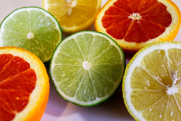 Fototapeta na wymiar Citrus fruit halves. Lemons, limes and oranges