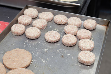 Closeup preparation of chicken cutlets for burgers. Bread crumbs and butter on the metal kitchen table. Ingredients. Concept restaurant business, fast food, tasty food, gastronomy, cooking, menu