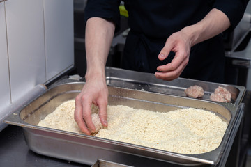 Fototapeta premium Chef hands creating, forming, breading chicken cutlet with knife on professional restaurant kitchen. Concept fast food business, preparation for cooking, menu, gastronomy, burgers, patty, meatballs