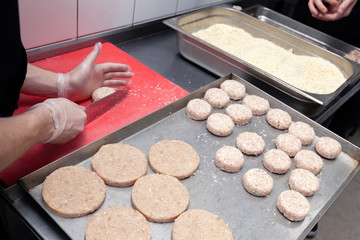 Chef hands in gloves creating forming chicken cutlets with knife for burgers. Ingredients. Concept restaurant business, fast food, preparation for cooking, gastronomy, patty, meatballs, menu