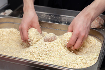 Chef hands creating, forming, breading chicken cutlet with knife on professional restaurant kitchen. Concept fast food business, preparation for cooking, menu, gastronomy, burgers, patty, meatballs