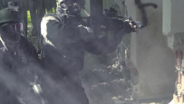 Slow Motion &ndash; Four Special Soldiers controll outside some bedraggled kennels.