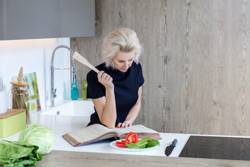 young blond woman cooking in modern kitchen