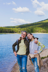 Funny Caucasian teenagers by the lake on a background of hills in Zabljak Montenegro on a sunny day.