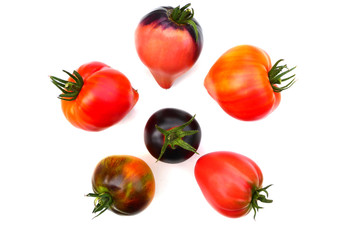close up of tomatoes in red, orange and violet colors isolated on white background