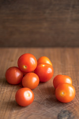 Fototapeta na wymiar Fresh tomatoes on wooden table over bokeh background white knife beside