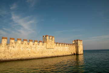 Scenic view of the boundaries of the dockyard of Scaligero Castle, one of the better preserved castles of Italy, over that rare example of lake fortification, Sirmione, Lake Garda, Lombardy, Italy