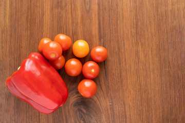 tomatos and red bell pepper on a wodden table cuttingboard with space for text copy space