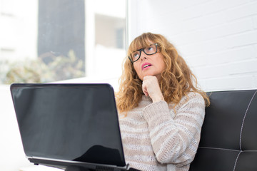 adult woman or senior with laptop on the couch