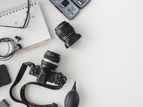 top view of work space photographer with digital camera, flash, cleaning kit, white table background.