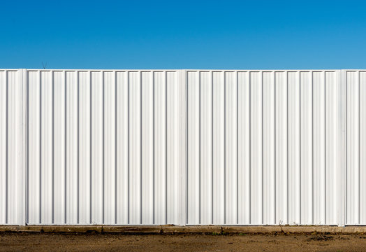 Two panels of a white metal fence