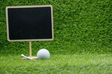 Golf ball with board on green grass