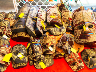 Fototapeta na wymiar Wooden masks in the local market, Rarotonga, Aitutaki, Cook Islands. With selective focus.