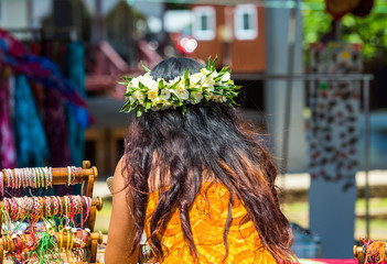 Girl with a white wreath of flowers, Rarotonga, Aitutaki, Cook Islands. With selective focus. Back view.