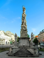 Kosice, Slovak Republic - May 2, 2018: Marian and Holy Trinity column in Kosice, close-up, vectical. Plague pillar on the background of the urban landscape of a small medieval town