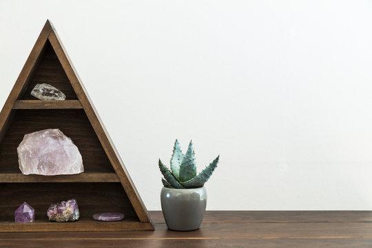 Triangular Crystal Shelf on a Wooden Surface with Potted Succulent Plant
