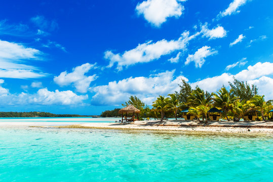 Stunning tropical Aitutaki island with palm trees, white sand, turquoise ocean water and blue sky at Cook Islands, South Pacific. Copy space for text.